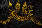 Wat Xieng Thong temple in Luang Prabang, Laos. Detail of the  intricate gold stencilling on black lacquer that decorate the walls of the sim. 